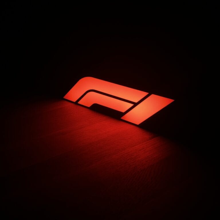 Moderné LED logo Mackom3D s červeným osvetlením na čiernom pozadí.